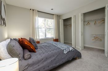 A bedroom with a bed and some closet space